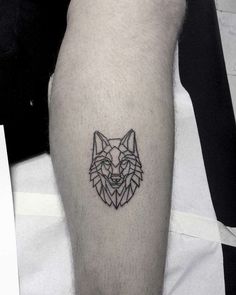 a man with a tattoo on his leg that has a wolf head in the middle