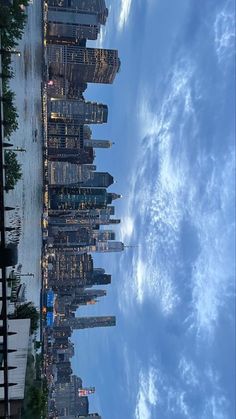 the city skyline is lit up at night with clouds and blue sky in the background