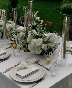 the table is set with candles, plates and napkins for an elegant wedding reception