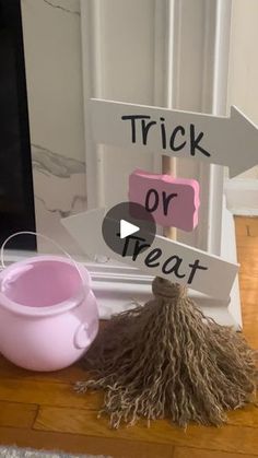 a sign that says trick or treat next to a cup and broom on a table