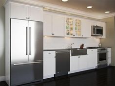 a kitchen with white cabinets and stainless steel appliances