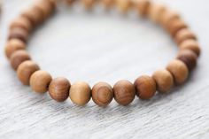 Handmade in Nepal, our natural wood bead bracelet looks great on both men and women. The simple design wears well on it's own or with a stacked combination of your favorite bracelets or wrist malas. As these natural wood beads are from the earth, they will directly remind you of your connection to nature and your potential to grow. The healing power of wooden prayer beads is often in their scent, which is released and revived with usage. Wood also provides stability and grounds mentally, physica Mens Wooden Bracelet, Wooden Bead Bracelet, Sandalwood Bracelet, Sandalwood Mala, Mala Jewelry, Adjustable Knot, Wrist Mala, Wood Bead Bracelet, Wooden Bracelet