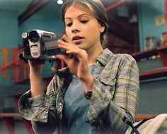 a woman holding a camera up to her face