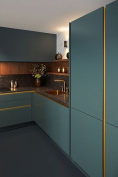 a kitchen with blue cabinets and gold trim on the counter tops is seen in this image