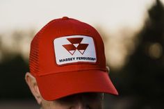 Hat with mesh back featuring the Massey Ferguson tractor logo. Emblem is sewn for durability. 6-panel structured hat. Red Trucker Hat For Outdoor, Red Six-panel Trucker Hat For Outdoor, Red Six-panel Trucker Hat For Sports Events, Red Trucker Hat With Curved Brim And Logo Patch, Red Six-panel Trucker Hat For Sports, Red 5-panel Trucker Hat For Sports, Red Breathable Trucker Hat, Tractor Logo, Ferguson Tractor