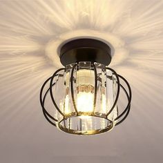 a light that is hanging from the ceiling in a room with white walls and flooring