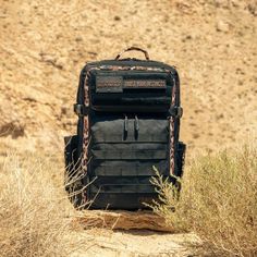 an old backpack sitting on top of a dirt hill in the middle of dry grass