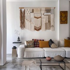 a living room filled with white furniture and lots of pillows on top of it's walls