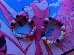 two bracelets that are sitting on top of a pink and blue wall with flowers