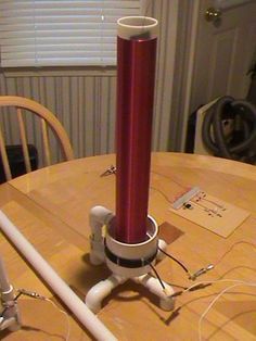 a table with a red lamp on top of it next to a white phone charger