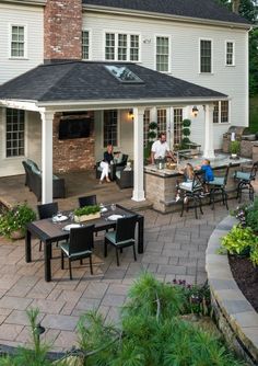 an outdoor dining area with patio furniture and brick pavers flooring, surrounded by greenery