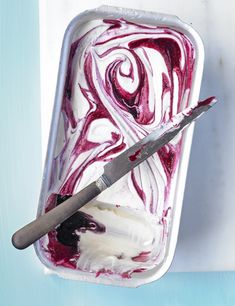 a container filled with ice cream next to a pair of scissors on top of it