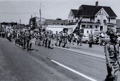 a group of people walking down the street in front of some trucks and motorcycles with flags on them