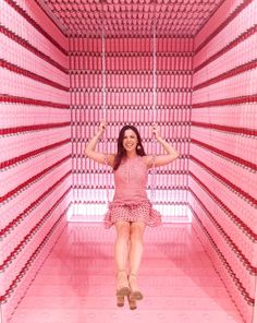 a woman sitting in the middle of a pink room