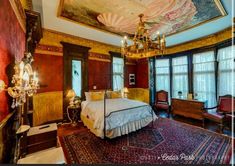 an ornate bedroom with chandelier and paintings on the ceiling