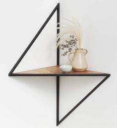 a shelf with a vase and some plants on it