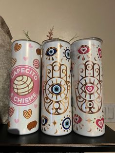 three coffee cans with different designs on them