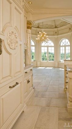 an ornate kitchen with white cabinets and chandelier