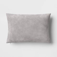 a gray pillow on a white wall