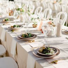 the table is set with plates and place settings