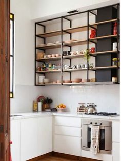 a kitchen with open shelving above the stove