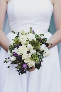 a bridal holding a bouquet of white and green flowers