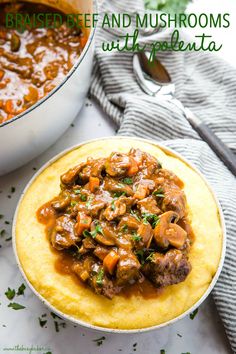 a white plate topped with mashed beef and mushroom stew next to a skillet