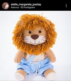 a stuffed animal lion wearing a blue dress and sitting on top of a white floor