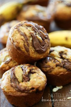 chocolate chip muffins stacked on top of each other with bananas in the background