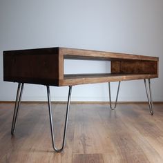 a wooden table sitting on top of a hard wood floor next to a white wall