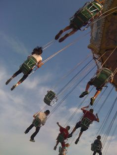 several people are hanging upside down on the merry - go - round at an amusement park