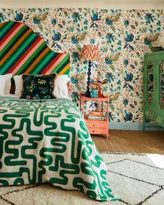 a bedroom with colorful bedding and wallpaper