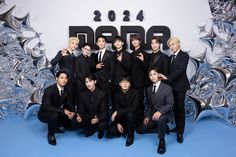 a group of young men in suits posing for a photo with their hands on their hips