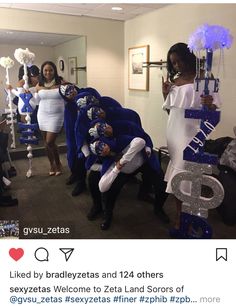 some people dressed in blue and white posing for a photo with one person holding a sign