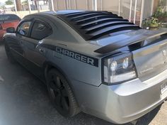 a silver car parked in front of a building with the word charger on it