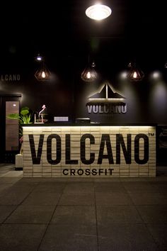 a sign that says volcano crossfit in front of a counter with lights above it