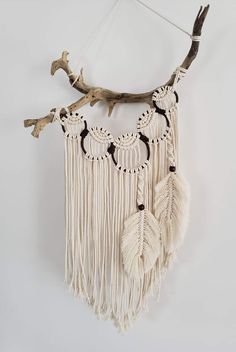 a wall hanging made out of driftwood and macrame with tassels