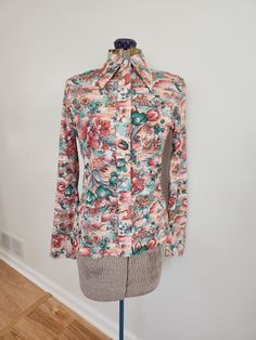 This vintage shirt is a fun addition to any groovy wardrobe. Just a Min-Knit Circa 1970s The shirt features a floral pattern and pointed collar. Tag size: small Shoulder to hem length: 21.75 inches Sleeve length: 23.75 inches Chest: 33 inches Waist: 30 inches There is light staining to the shirt, in a variety of spots. The stains are light and small enough, though, that they can be difficult to spot among the pattern. This is a French cuff shirt, but a previous owner sewed buttons at the wrists. The buttons can be removed. See last three photos. This shirt is still overall in good vintage condition with some wear and age. There are no holes or loose seams. Feel free to send me any questions! French Cuff Shirts, Lily Flowers, French Cuff, Wild Card, Button Down Blouse, Lily Flower, Collar Shirt, Vintage Shirt, Collar Shirts