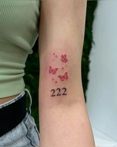 a woman's arm with the number 22 on it and butterflies in red ink