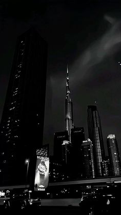 a black and white photo of a city at night with skyscrapers in the background