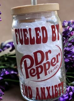 a jar filled with purple flowers sitting on top of a table