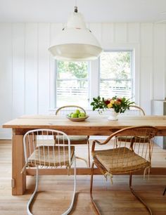 a table with two chairs and a bowl of fruit on it