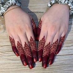 two hands with henna designs on them, one is red and the other is white