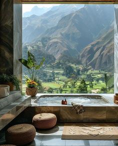 an outdoor jacuzzi with mountains in the background and flowers on the table next to it