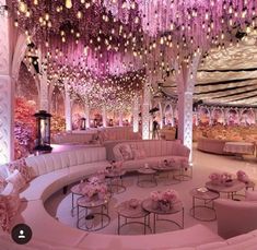 an elaborately decorated room with pink flowers and chandeliers hanging from the ceiling