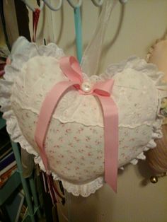 a heart shaped pillow hanging from a hook