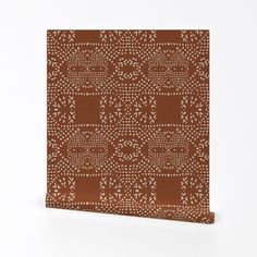 a brown and white wall hanging with an intricate design on it's side, in front of a white background