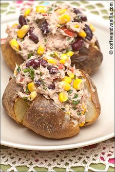 two loaded baked potatoes on a white plate