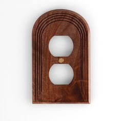 a wooden outlet cover with two white outlets in the center and one light switch plate on the other side