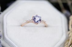 an engagement ring sits on top of a white box